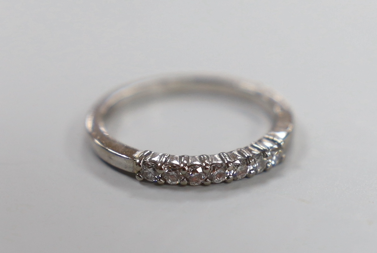 A modern 18ct white gold and seven stone diamond chip set half hoop ring, size K, gross weight 2.4 grams.